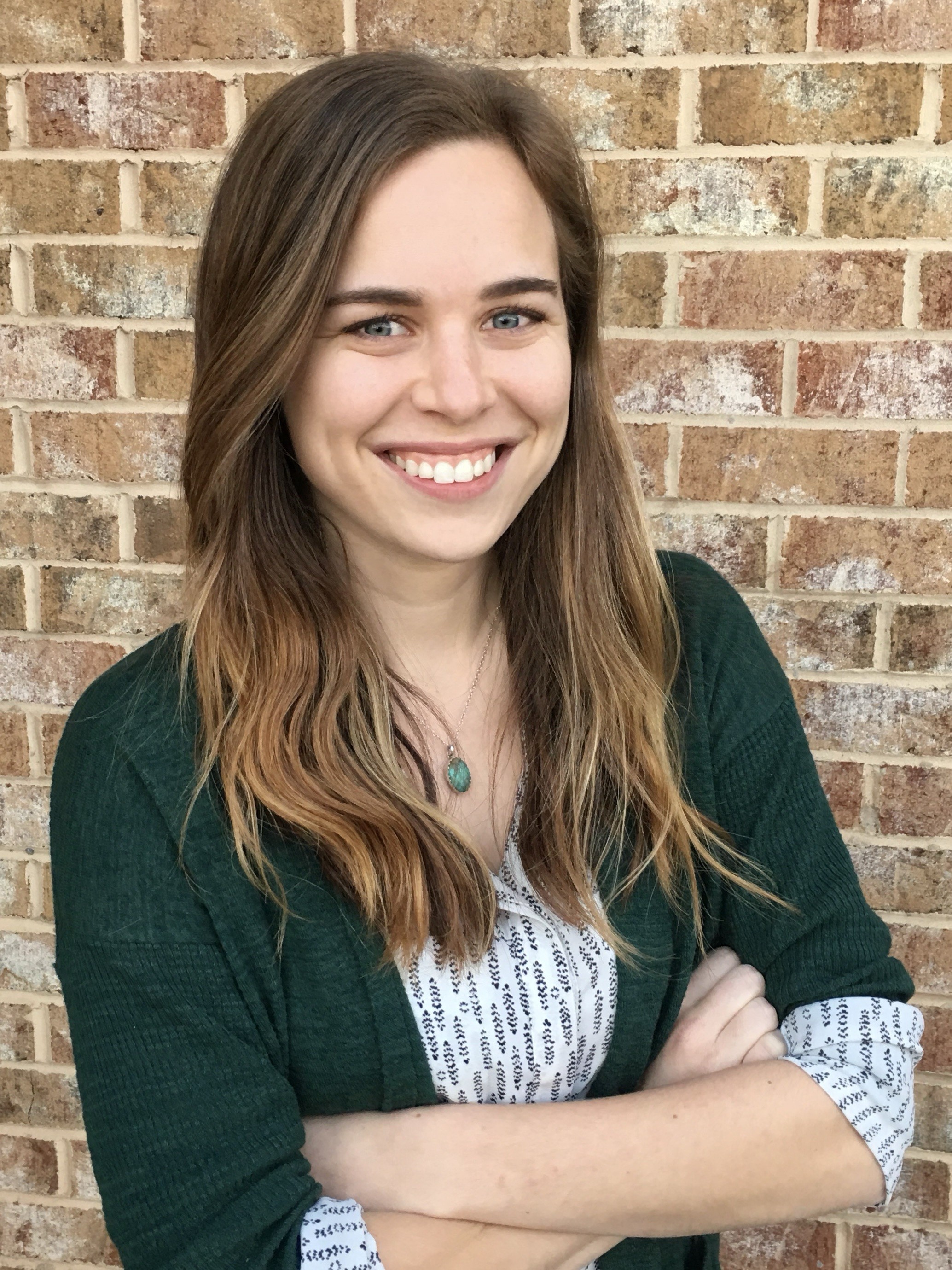 Katelyn Manga, Registered Dietitian, smiling in front of a brick wall